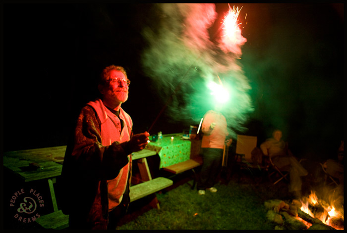 Sid Kaplan holding a sparkler at night.